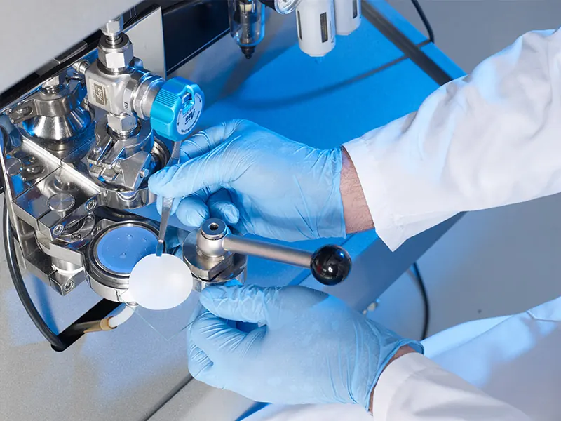 Laborantin arbeitet an einer Filtrationseinheit für die Restschmutzanalyse